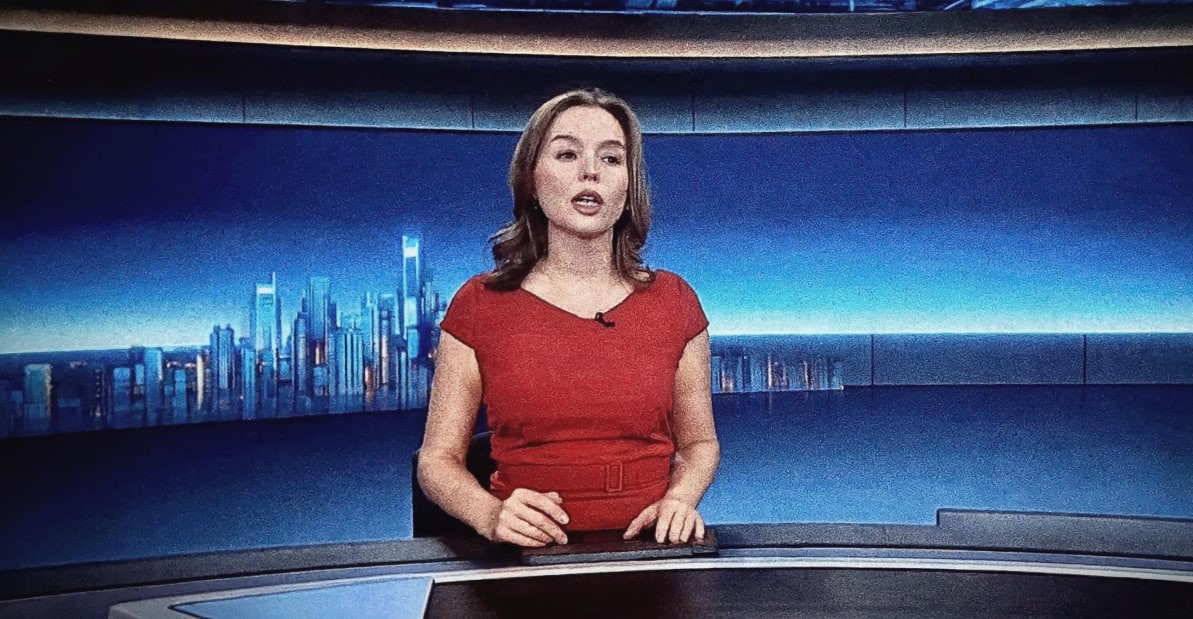 Moderatorin am Nachrichtenpult im Studio